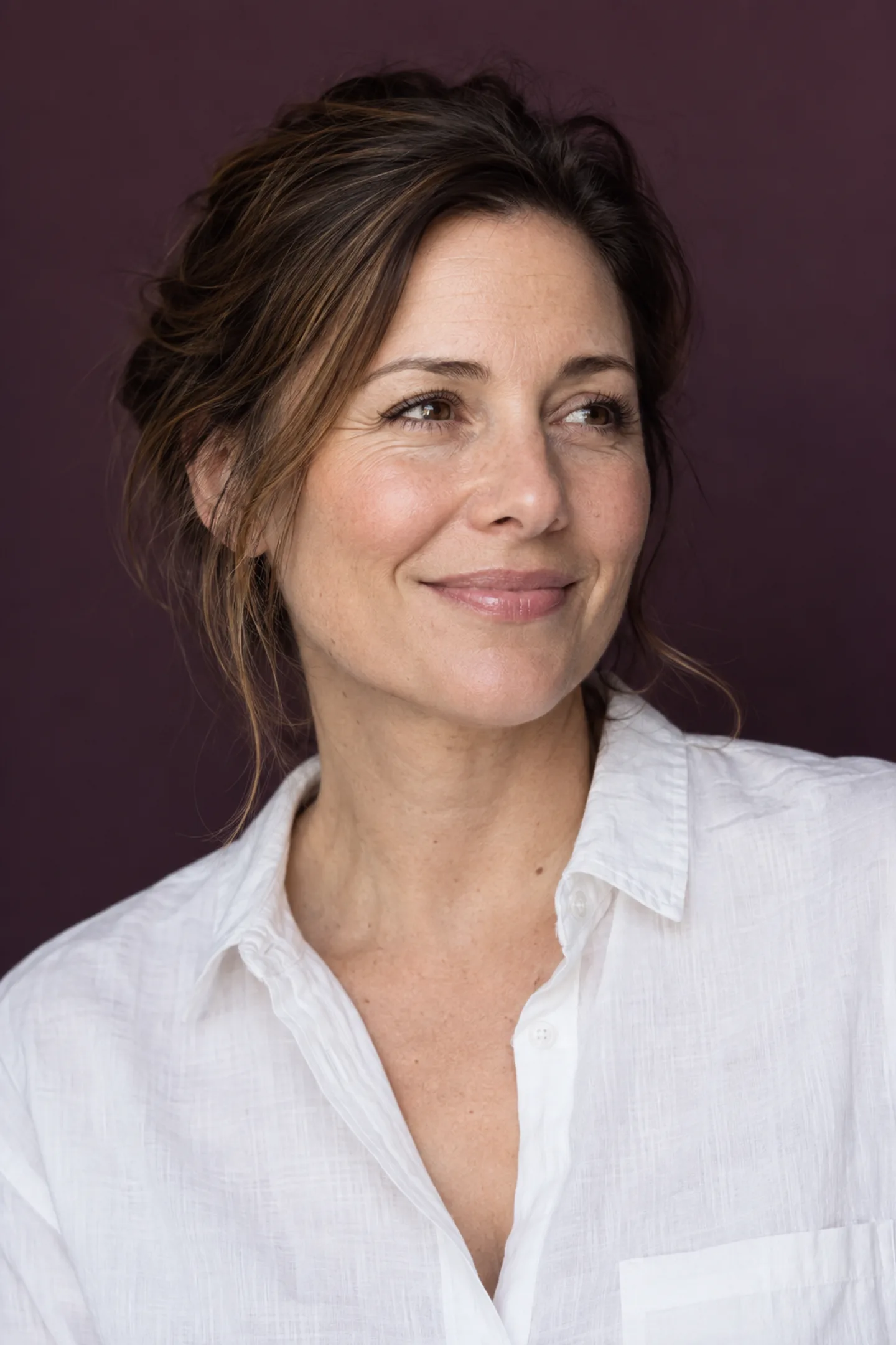 A woman with a relaxed smile in soft natural light